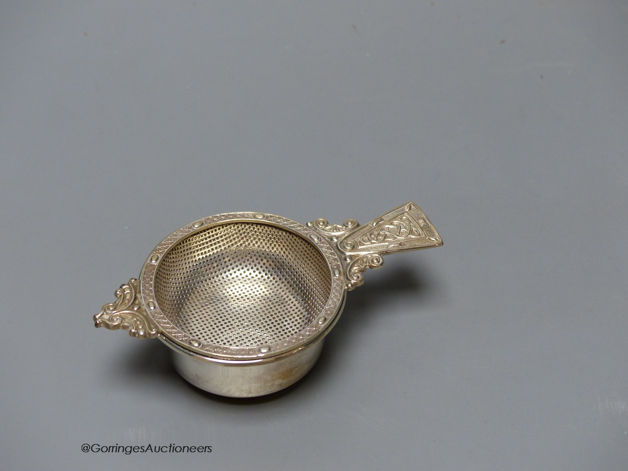 A modern silver tea strainer and stand by A.E. Jones Ltd, Birmingham, 1970, 10.9cm, 74 grams.